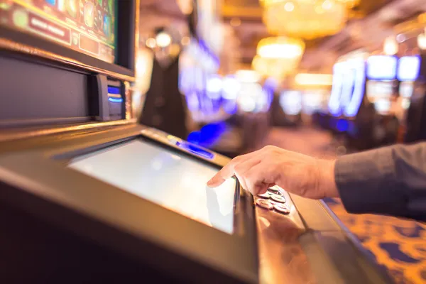 A man focused on his laptop with live stats in the background, highlighting the dedicated sports and gaming features of the 7C777 mobile app.